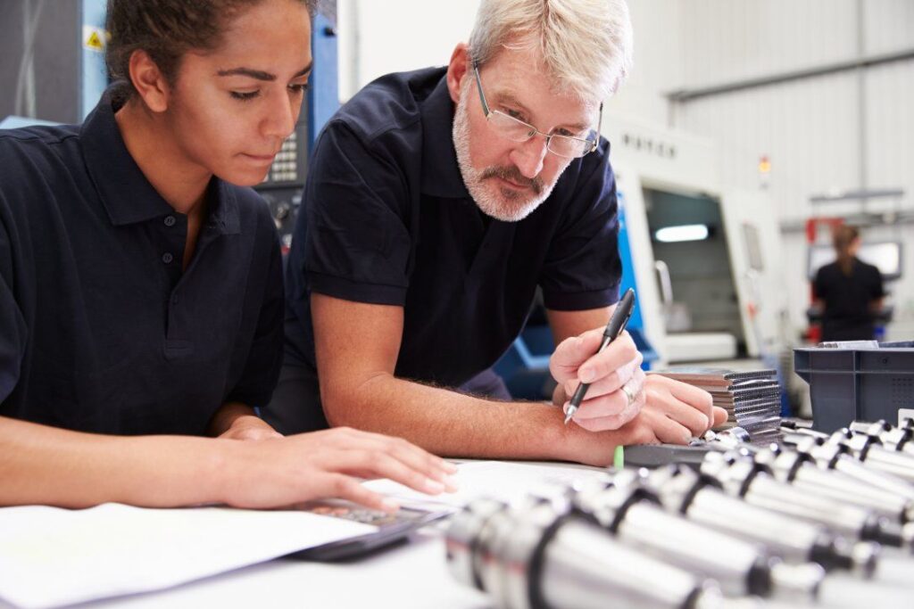 An engineering apprentice being tutored