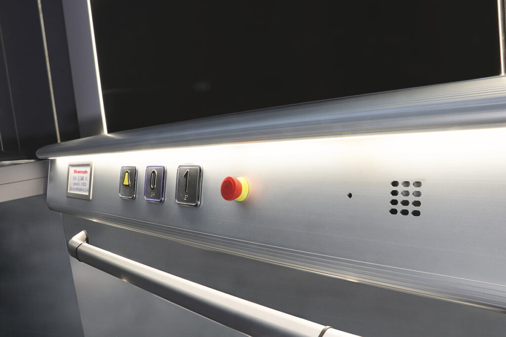 Car operating panel with square buttons and handrail in natural anodised aluminium.
